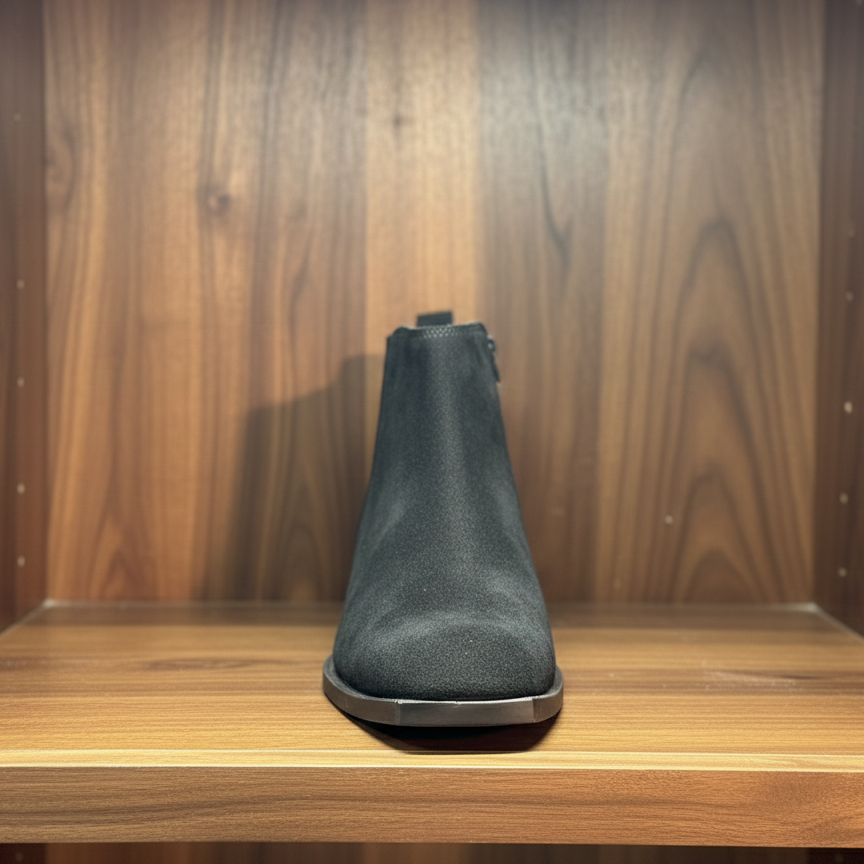 Black boot on a wooden shelf with a wooden paneled background